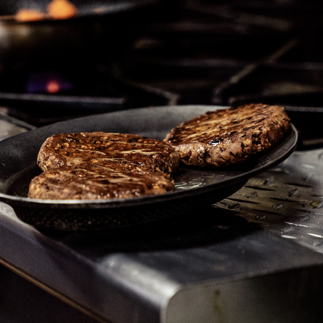 Skillet Patties Three Bahama Burger patties being fried in a skillet